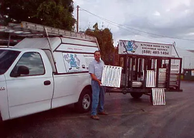 David A. Nowack standing beside early company vehicles and equipment